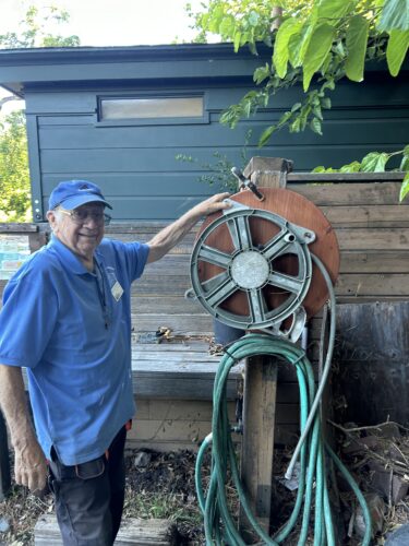 Wall-mounted garden hose reel being shown off by the builder.